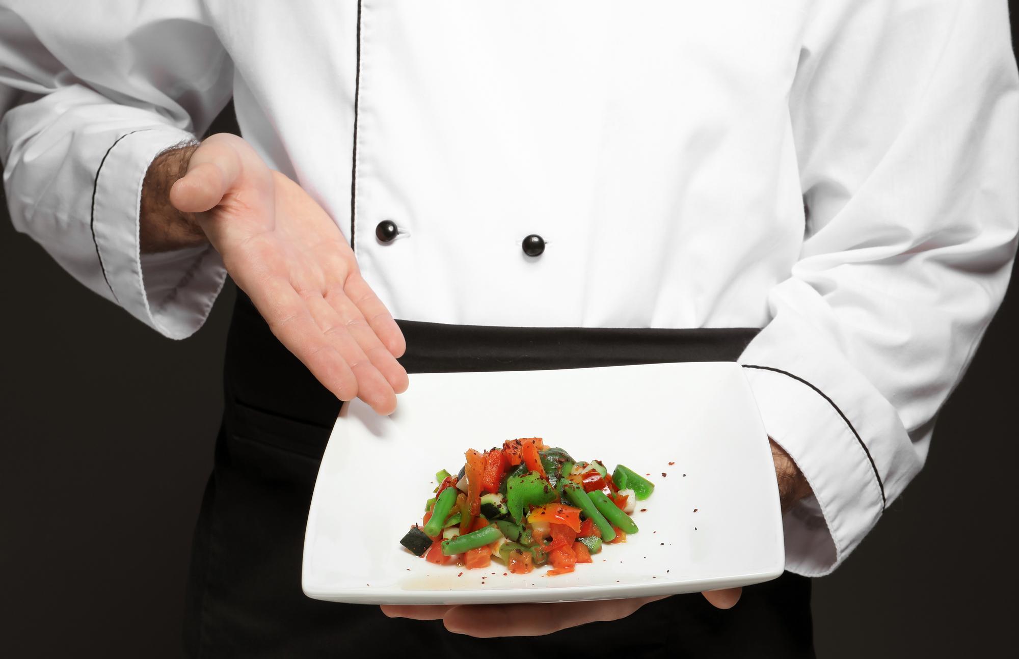 Chef plating a modern dish in professional kitchen